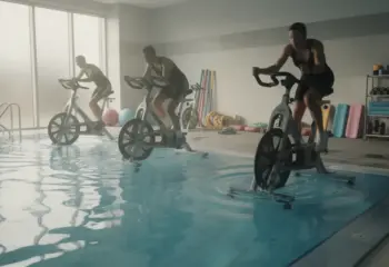 Salle aquabike moderne, silhouettes adultes sur vélos aquatiques